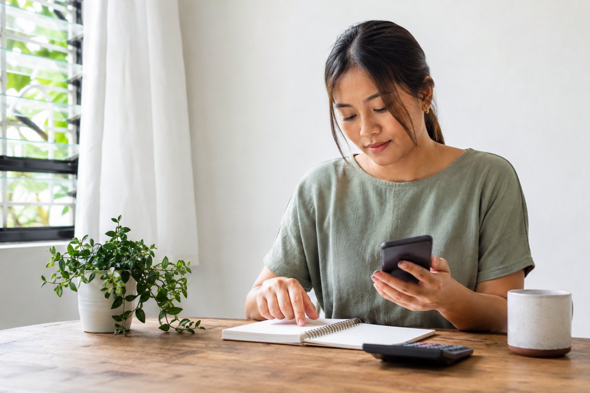 Illustrative scene of a woman reviewing a notebook beside a calculator