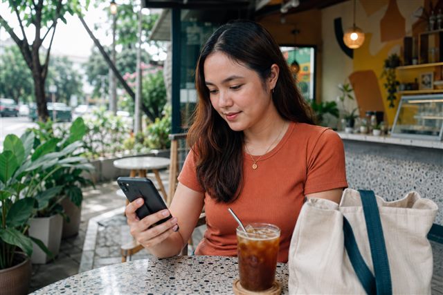 A woman checking her phone at a neighborhood café